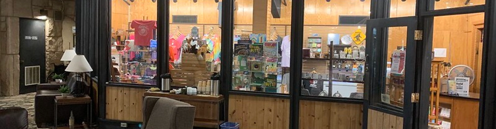 Lodge gift shop featuring displays of souvenirs, apparel, local products, and travel essentials in a warm, welcoming setting.